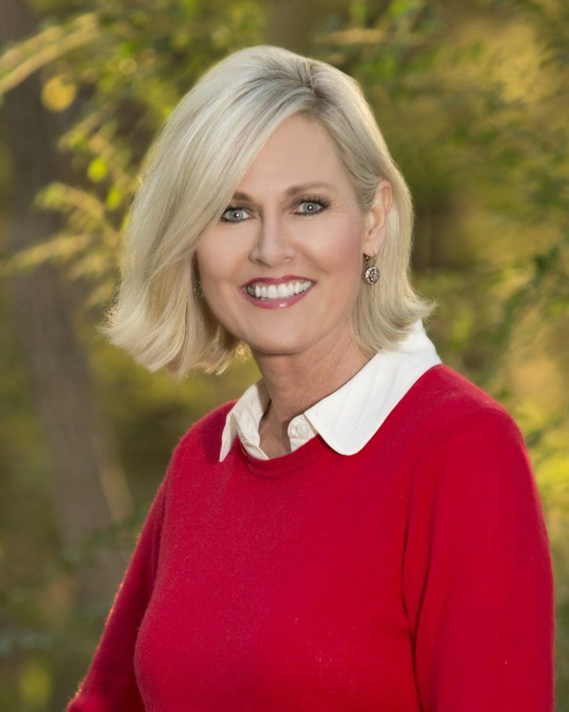 A woman in red shirt smiling for the camera.